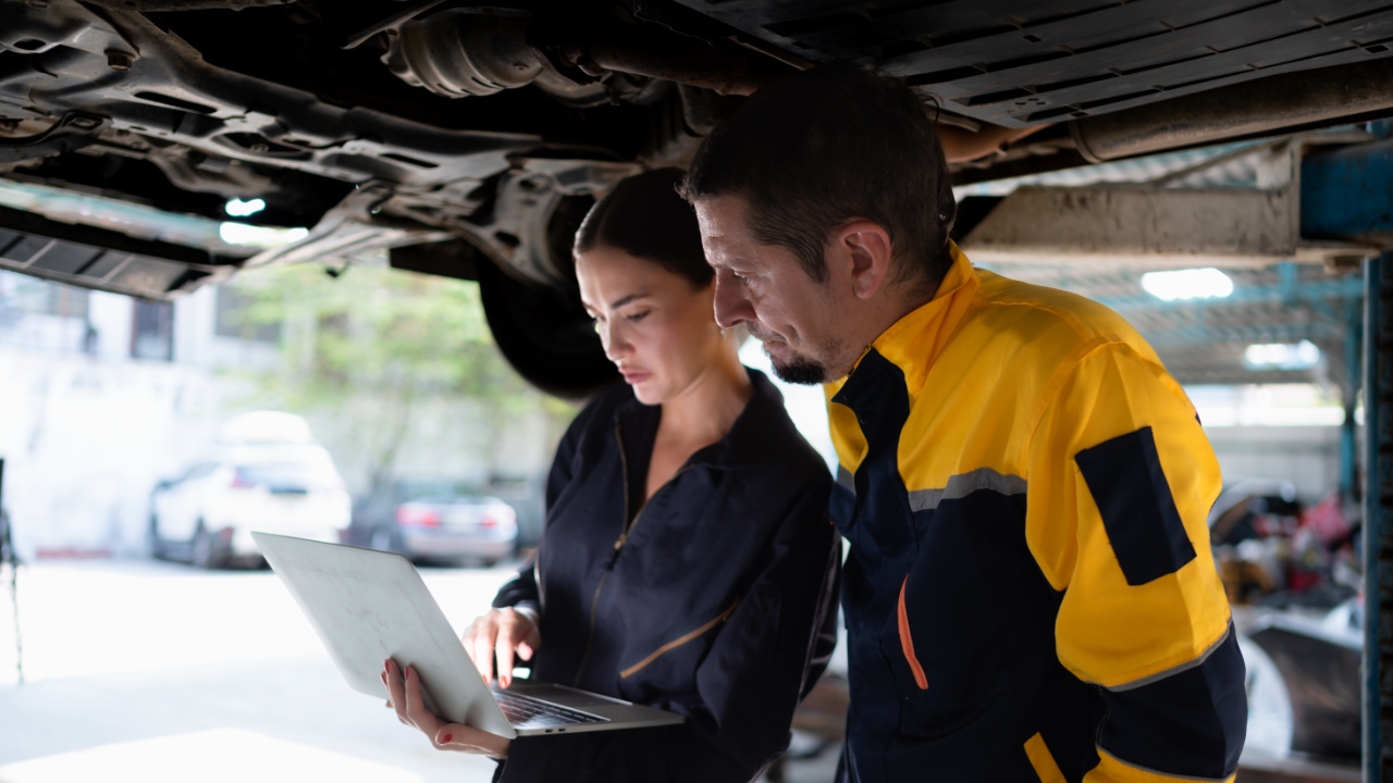 2 personnes en train d'inspecter un véhicule
